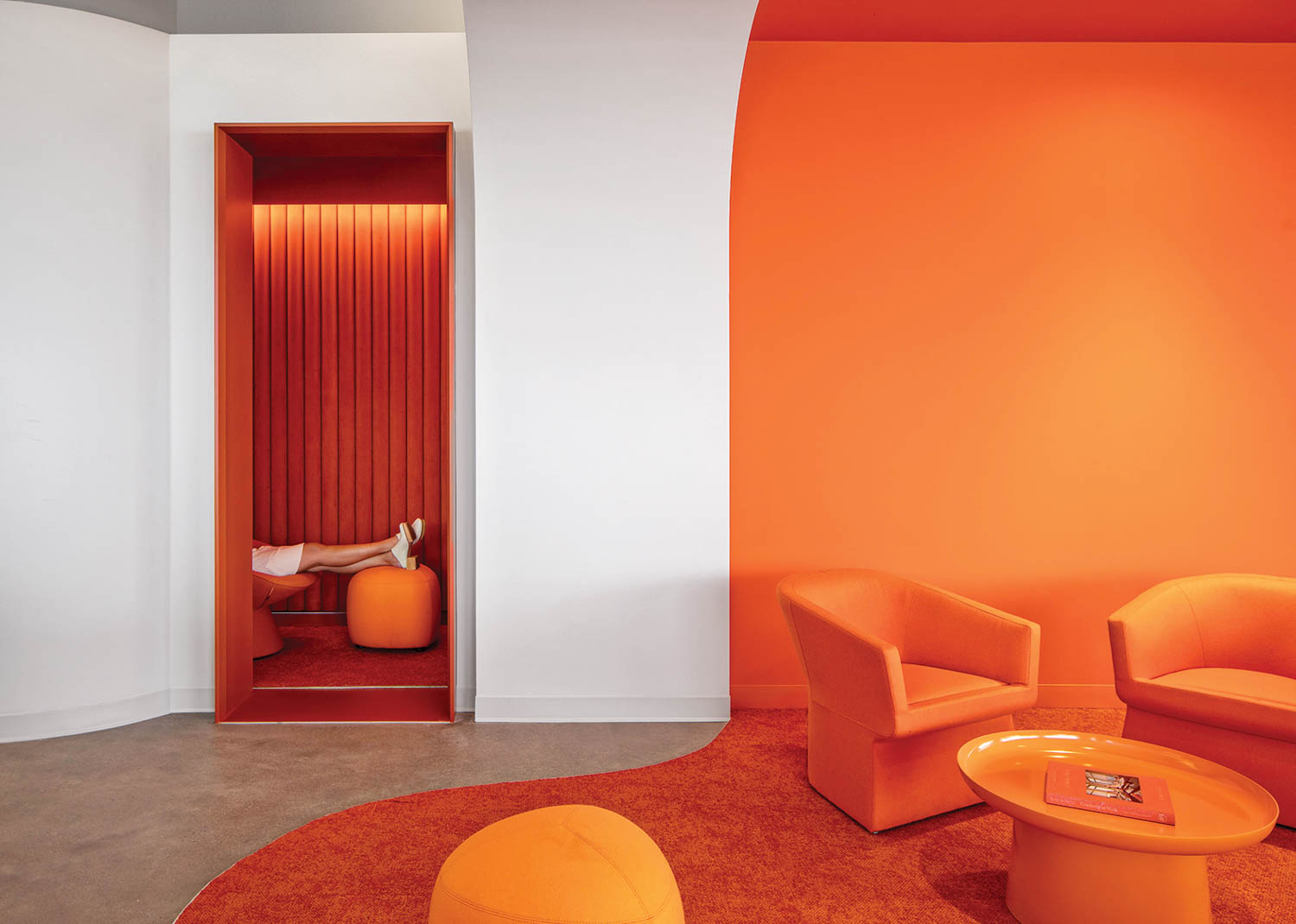 a bright orange offie area with orange armchairs