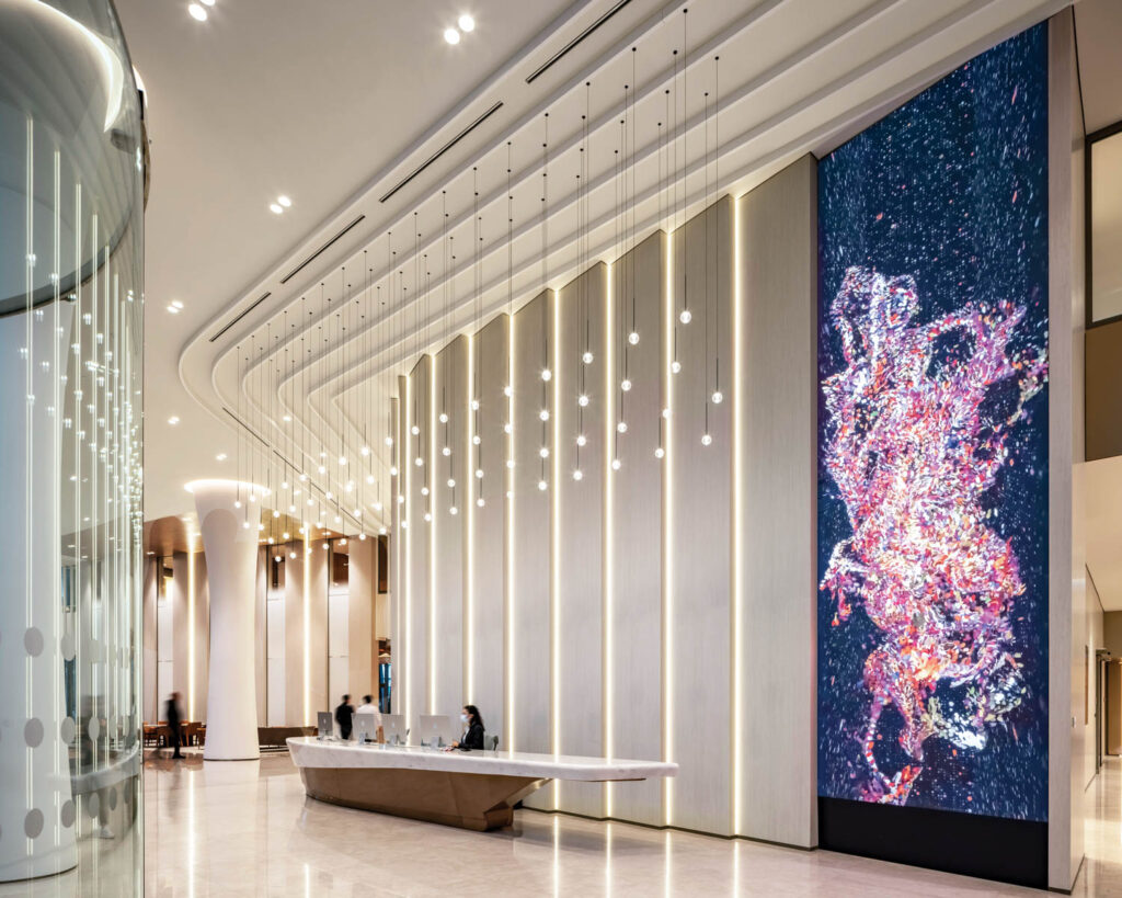 a reception desk and massive digital artwork on display in the lobby of Acibadem Healthcare Group