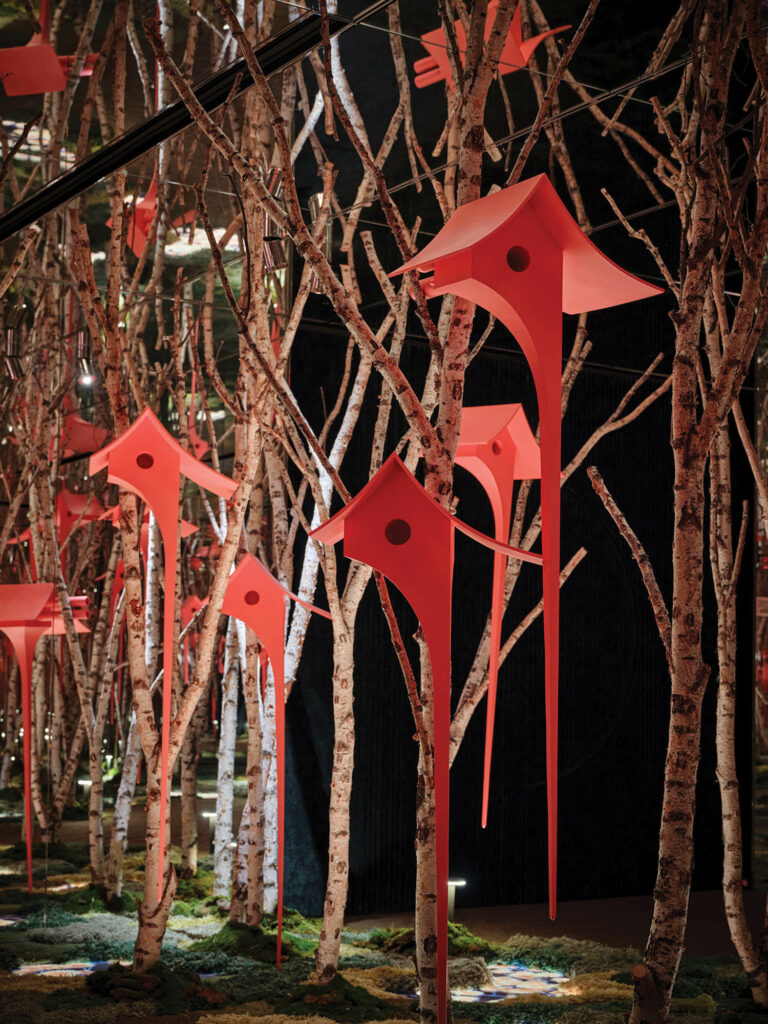 an installation of a secret forest with red birdfeeders