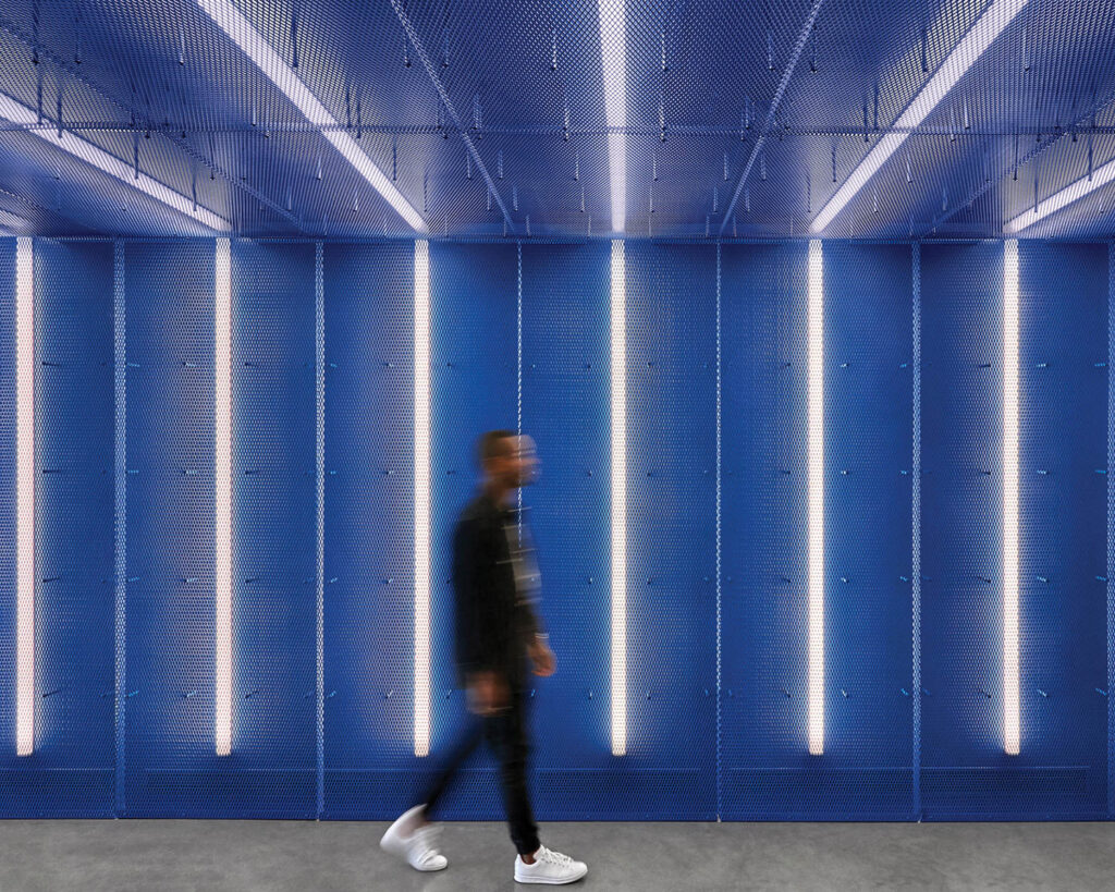 a blue hallway with vertical LED lights at Adidas