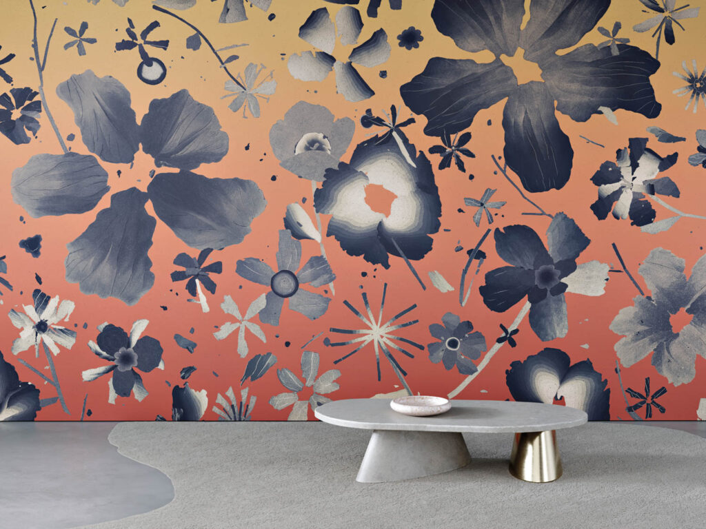 a gray table in front of vibrant orange wallpaper with gray flowers
