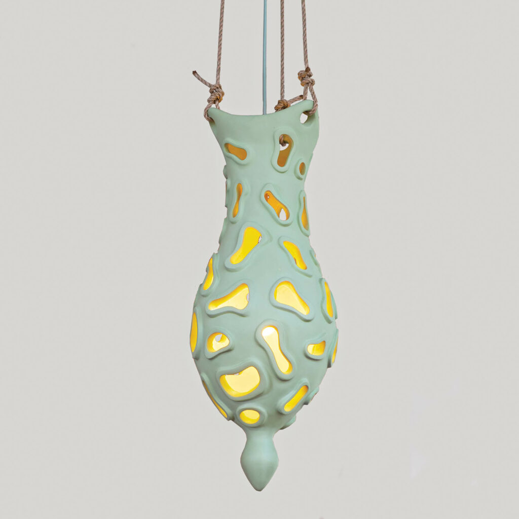 a light green pendant that holds a glowing light