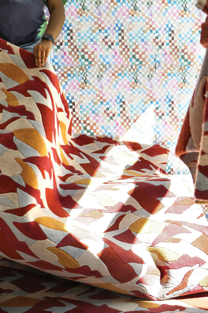 a red orange and white patterned textile with sunlight streaming in