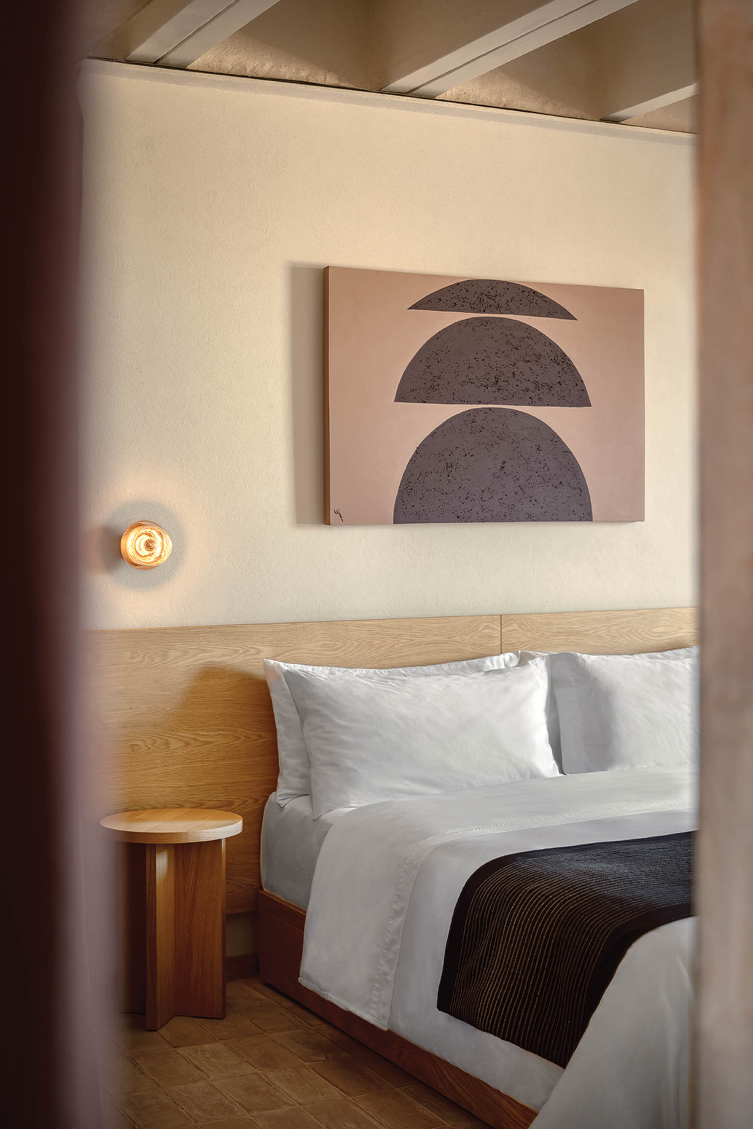 a guest suite in a Mexican Hilton hotel with an abstract artwork over the bed