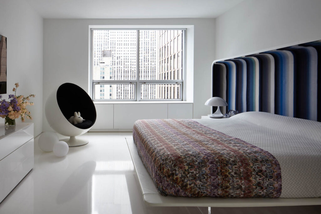 a floating platform bed in the primary bedroom of an apartment