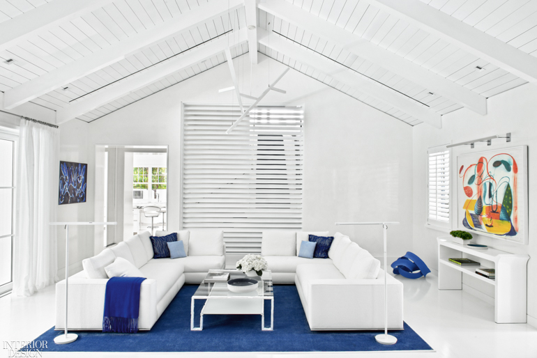 A white cathedral ceiling offers a beachy look when paired with white furnishings and a deep blue rug