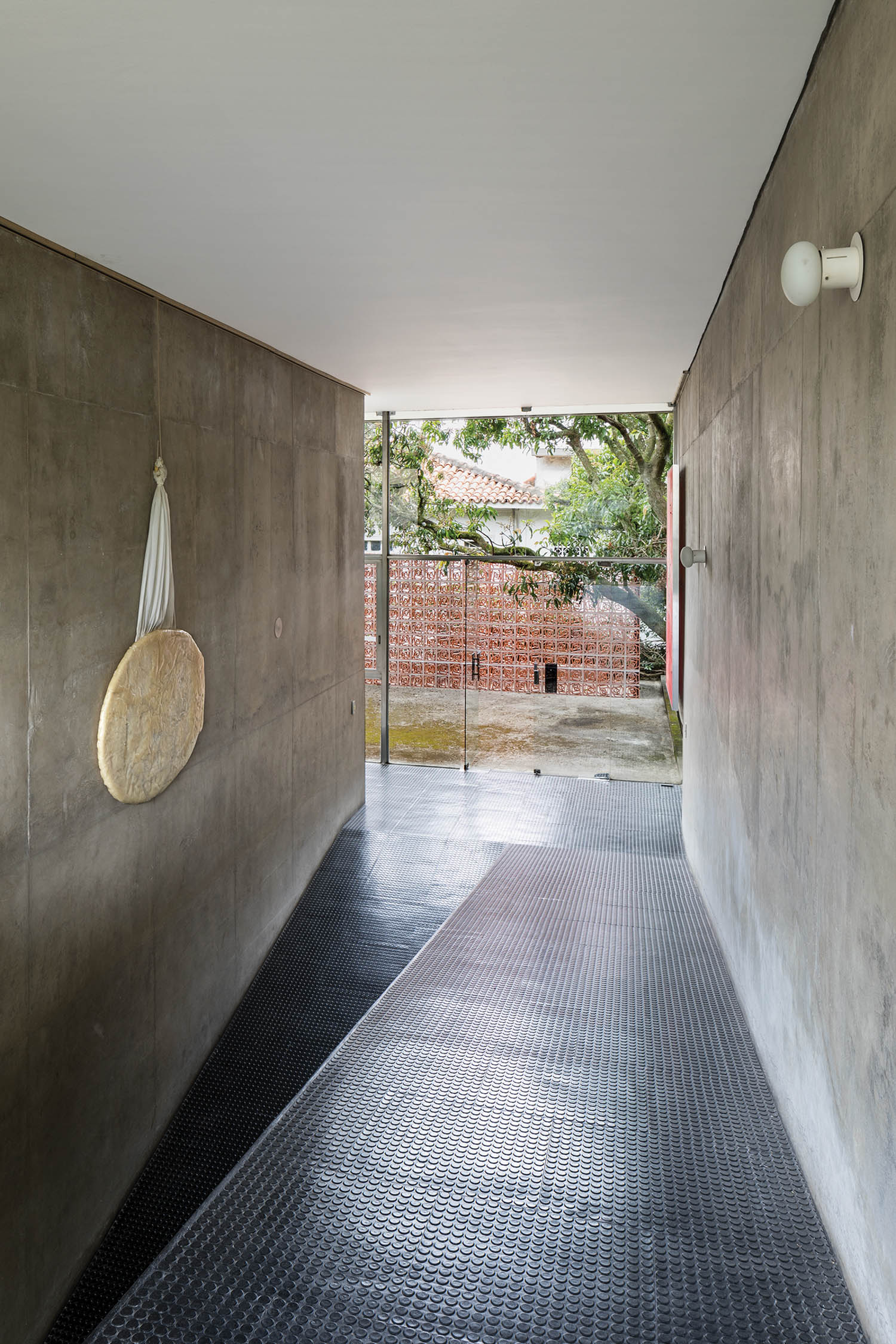 a hallway leads outside in this Brazilian modernist and Brutalist home
