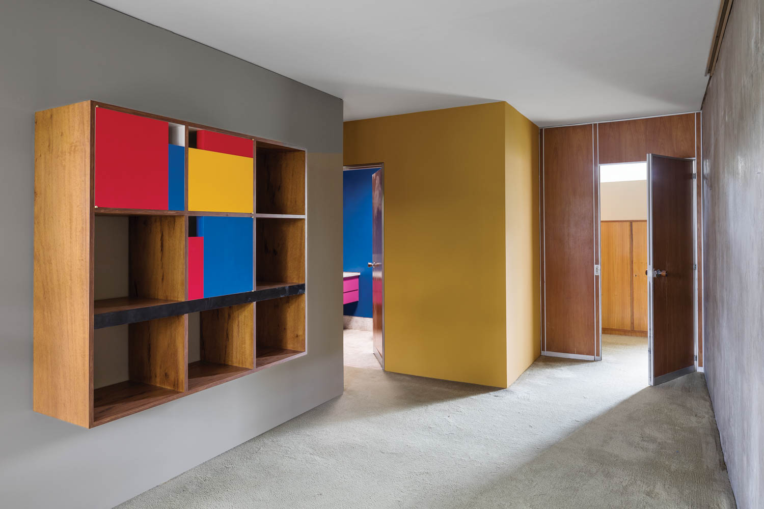 a square wall shelf with primary colors covering some of the openings