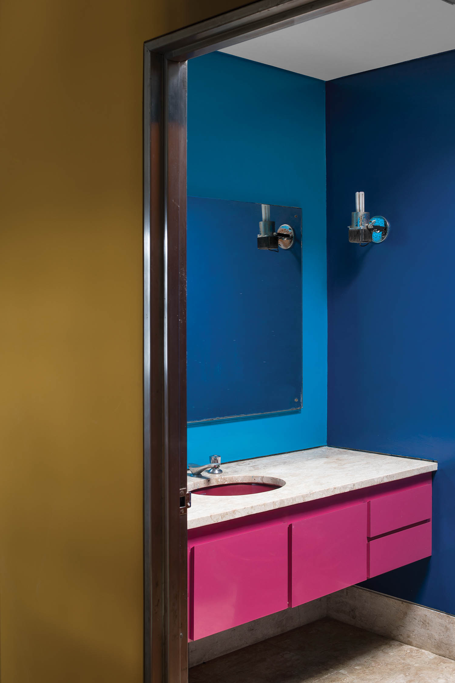 a pink vanity against blue walls in a bathroom