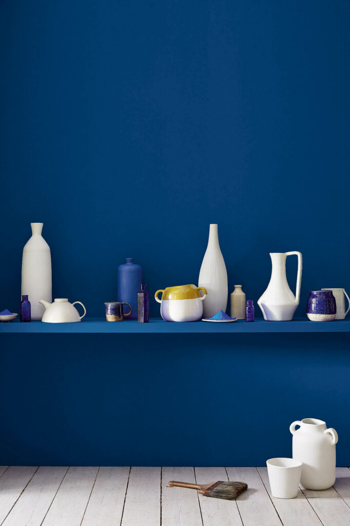 deep blue wall with pottery on a shelf