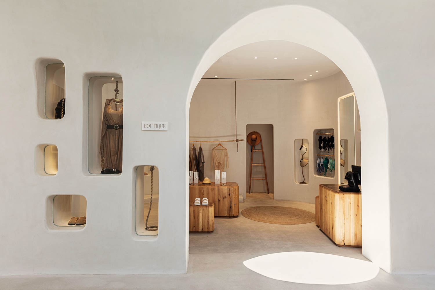 a curved arch doorway flanked by wall niches showcasing locally made goods