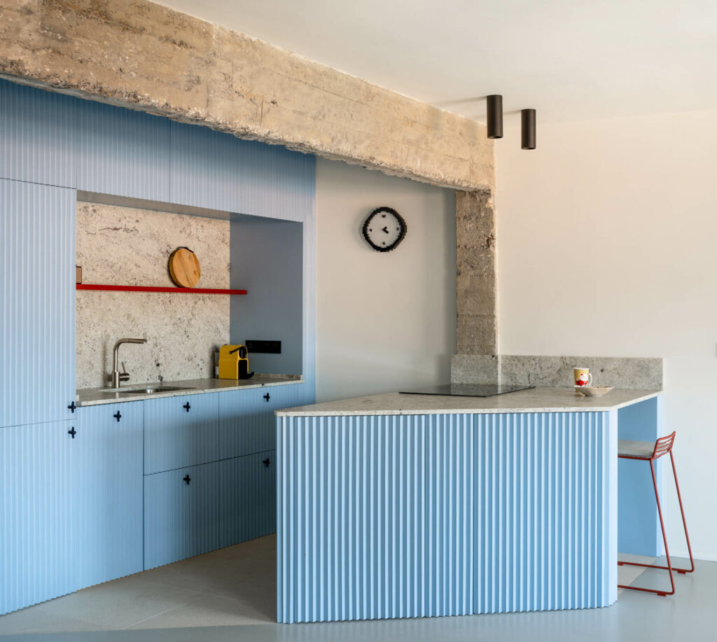 A blue kitchen with a blue island complete with a sink