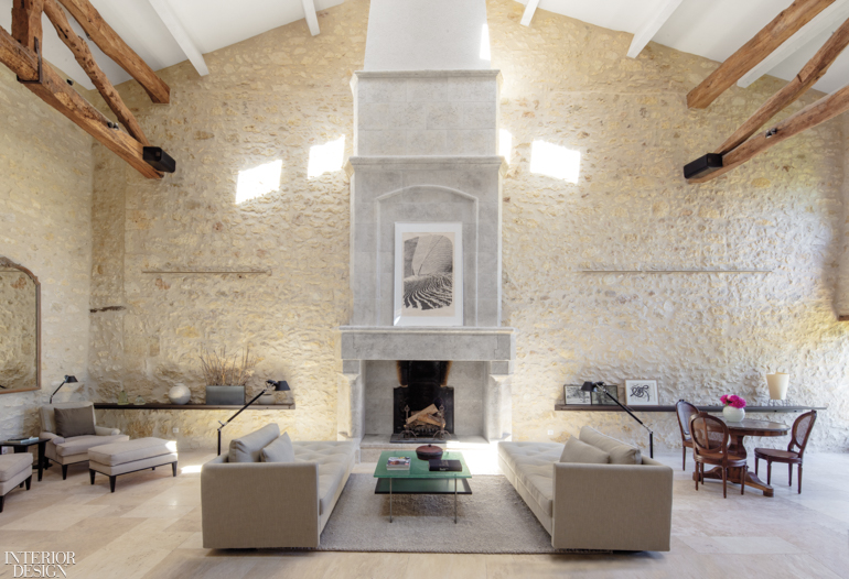 With a gray fireplace as the focal point, wooden beams, some natural and some painted white, draw the eye upward