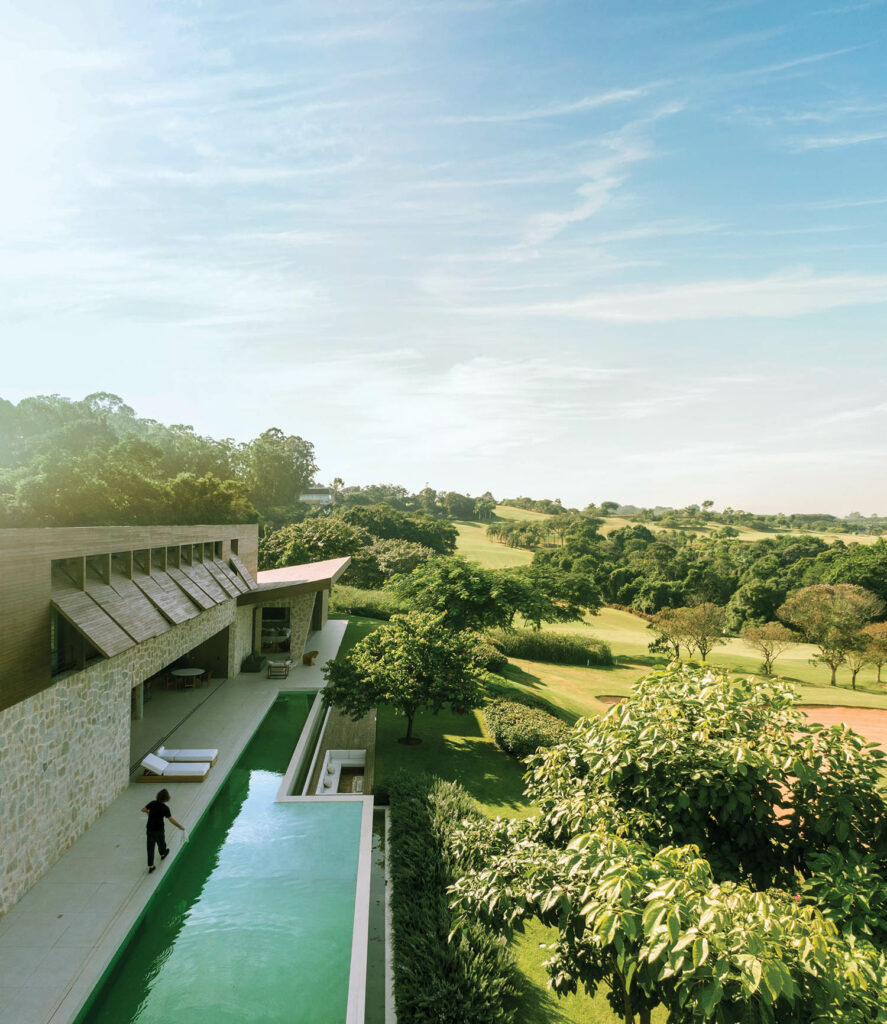 a long outdoor pool overlooks the lush landscape of this Brazilian home