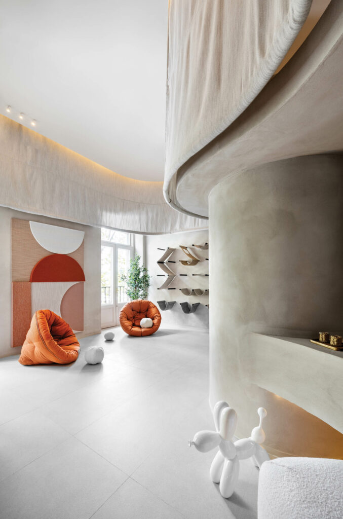 a room with orange chairs and cat hammocks with gray walls