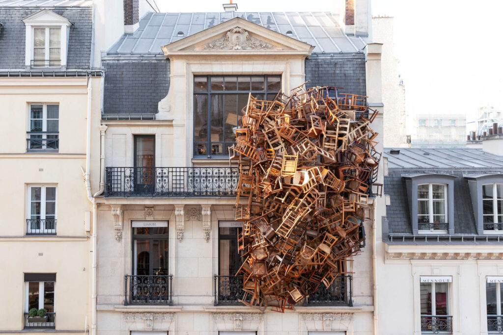 a townhouse in france with chairs spilling down the facade