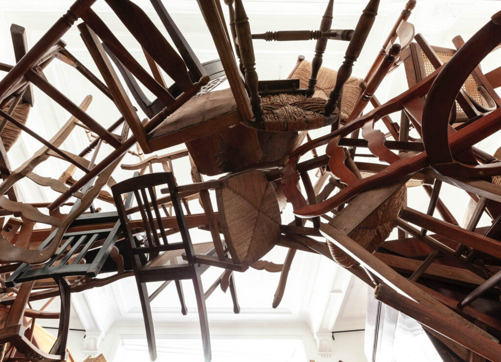 a close up shot at an installation made of wooden chairs
