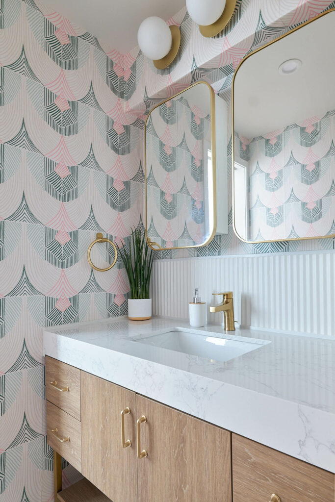 A bathroom sink with terrazzo counter and pastel patterned wallpaper