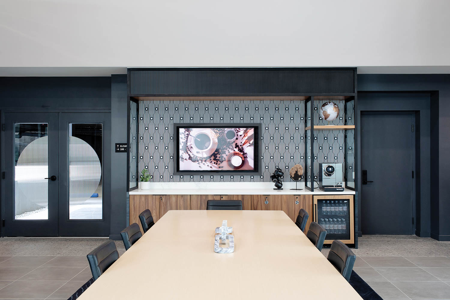 a long wood table in a room with dark gray walls