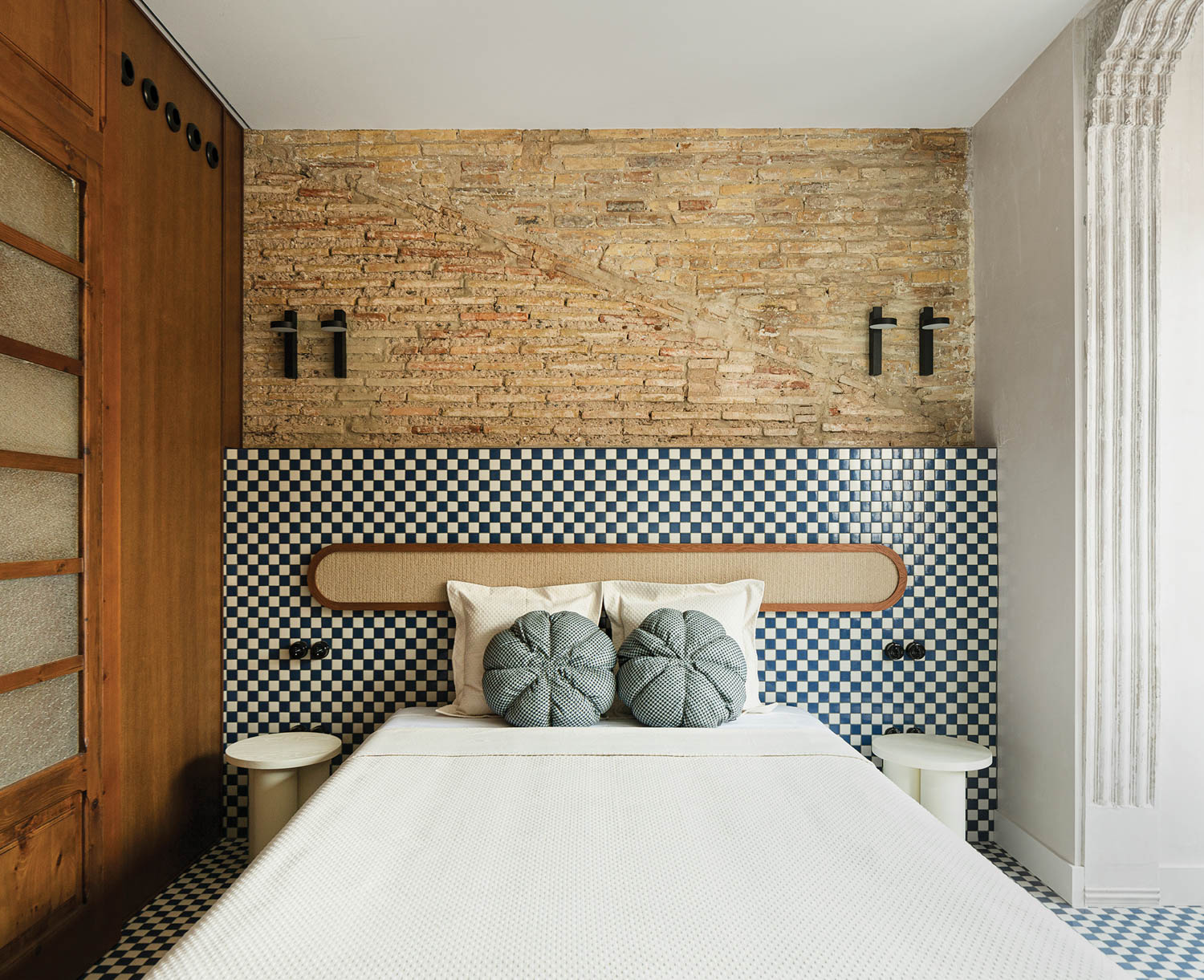 blue and white checkerboard headboard connects to brick above it